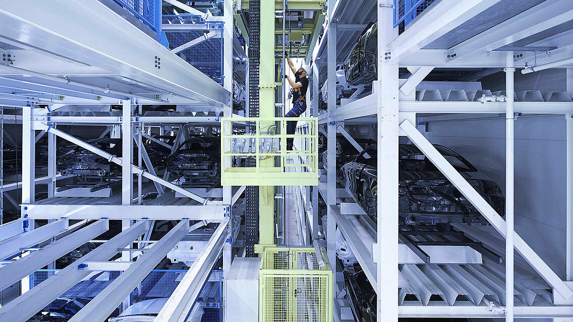 A Leadec employee carrying out maintenance in a high-bay warehouse.