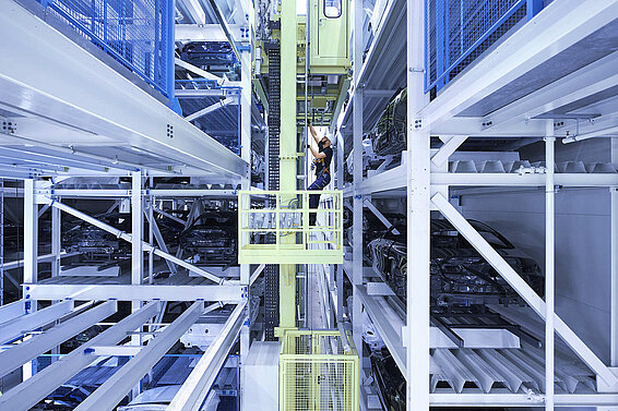 A Leadec employee carrying out maintenance in a high-bay warehouse.