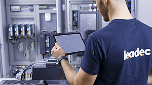 Leadec employee with a tablet checking switch cabinet.