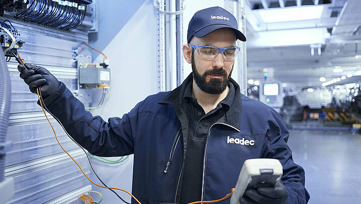 A Leadec employee analyzing faults and repairing installed electronics.