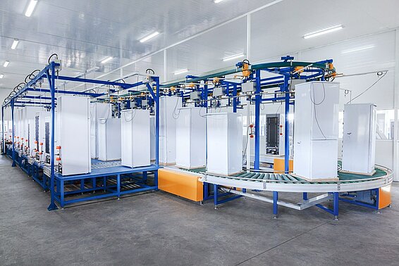 View of a conveyor belt with several refrigerators on it.