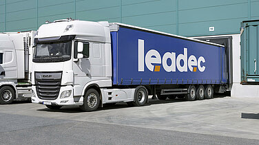 A Leadec truck at a docking system in front of a hall.