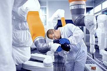 Leadec employee cleaning robot in a paint shop.